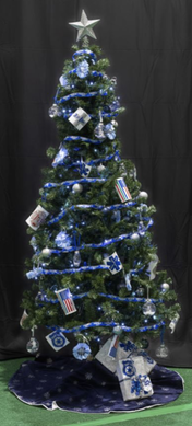 A Christmas tree decorated in blue and silver with themed ornaments, including stars, snowflakes, and healthcare-related items, set against a black backdrop.