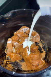 Pouring milk into the caramel and caramel creams mixture.