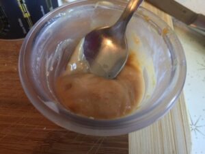 Glass bowl with 2 diced caramel creams and half & half mixed together into a sauce