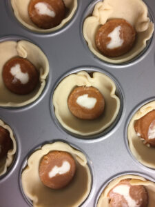 Caramel creams placed in each pie crust prepped for the oven