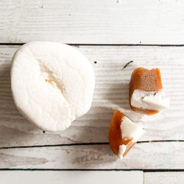 A large Marshmallow and a caramel cream cut in half