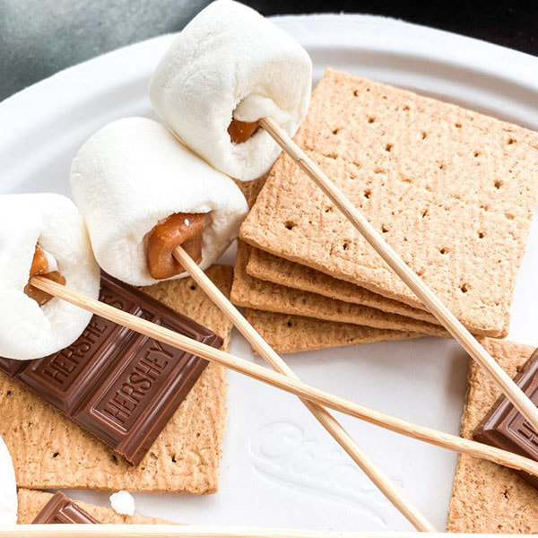 Stuffed marshmallows on a stick with graham crackers and chocolate